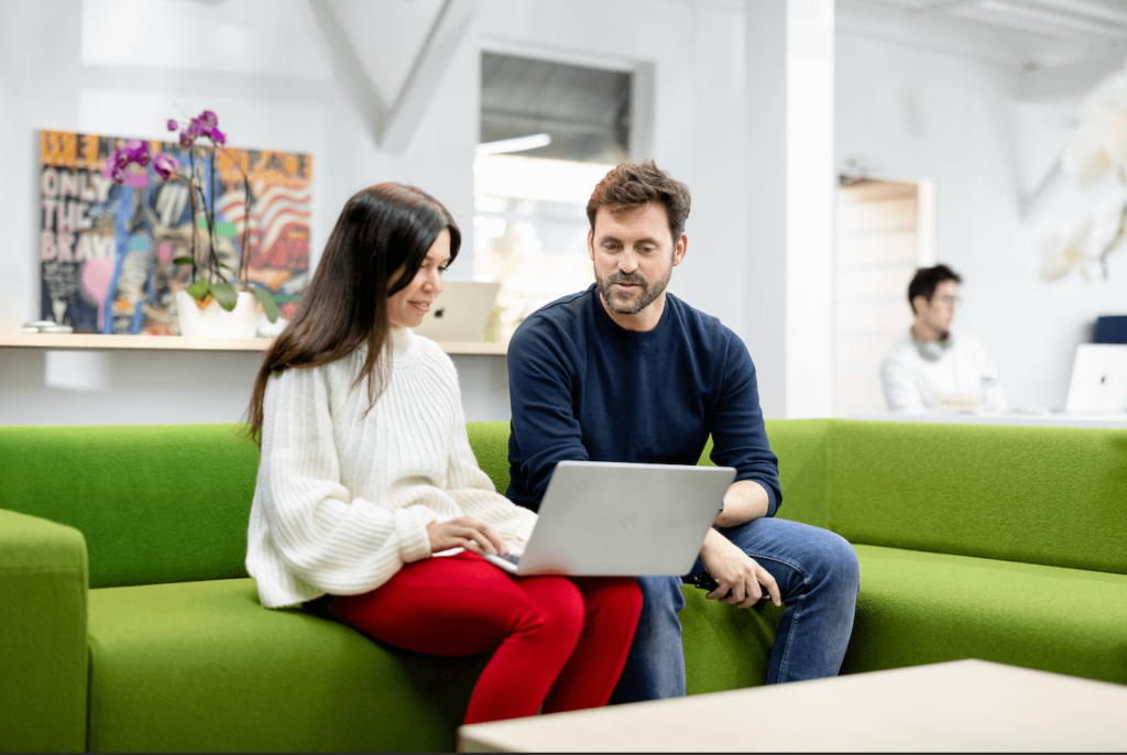 get into PearX accelerator session with founders reviewing progress on a laptop in a collaborative workspace