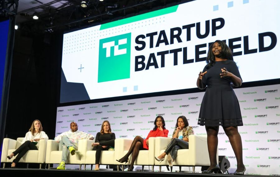 A startup founder pitching on stage at TechCrunch Startup Battlefield in front of a panel of investors and a live audience.