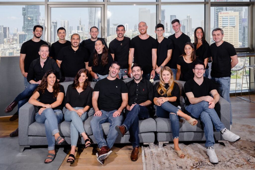 A group photo of the Fusion VC team members smiling together in a professional setting.