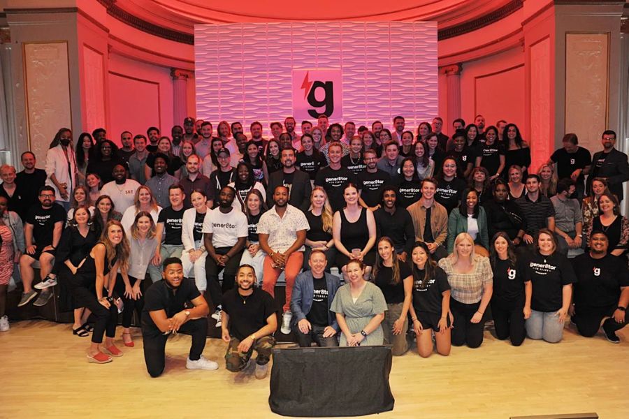 Startup founders presenting their pitches on stage at gener8tor Demo Day, with an audience of investors and mentors.