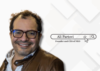 Ali Partovi, Founder and CEO of Neo, standing confidently in front of a branded Neo backdrop.