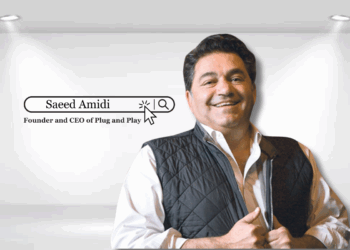 Portrait of Saeed Amidi, Founder and CEO of Plug and Play Tech Center, standing confidently in a modern office environment.