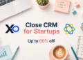 Desk-style Close CRM for Startups banner with XRaise logo, discount message, sales notes, laptop, and workspace items