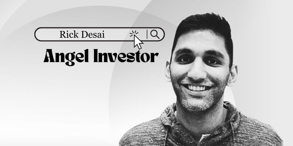 Rick Desai speaking on a Chicago tech stage, smiling with city skyline backdrop.