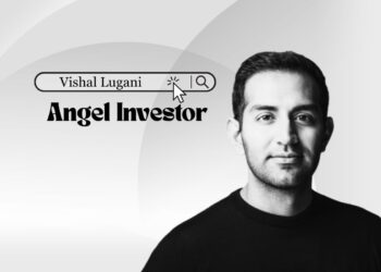Smiling Vishal Lugani in a blazer, New York skyline backdrop.