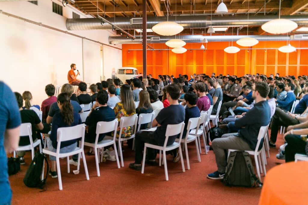 Visual depiction of a Y Combinator Accelerator Interview via Zoom, with a founder facing a panel of interviewers, capturing the fast-paced, high-stakes dynamic.