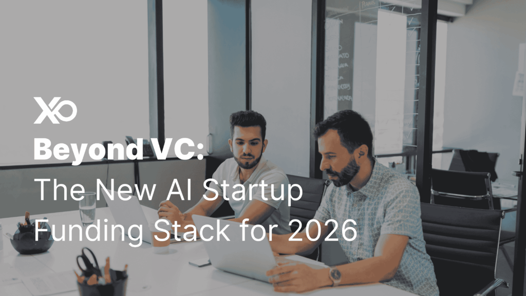 Two founders discussing AI startup funding strategies on a laptop in a modern meeting room