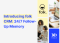 Introducing folk for startups CRM with 24/7 follow-up memory, showing a diverse team collaborating on laptops and charts in a modern workspace