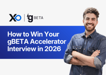 smiling founder in denim shirt beside banner reading “How to Win Your gBETA Accelerator Interview in 2026” with XRaise and gBETA logos