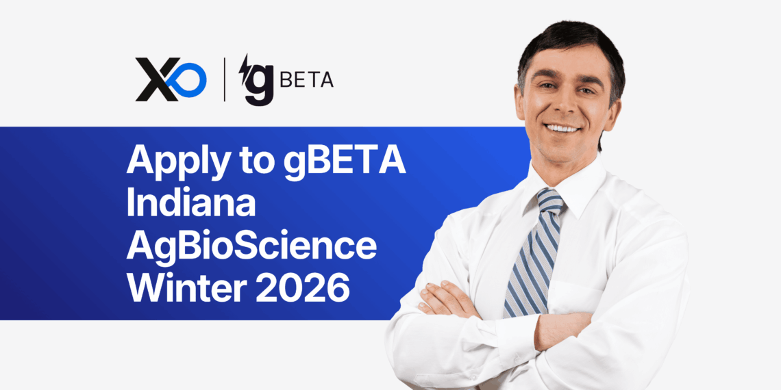 Smiling man in a white shirt and striped tie stands with folded arms beside a banner inviting founders to apply to the gBETA Indiana AgBioScience Winter 2026 accelerator.