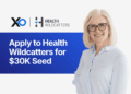 Apply to Health Wildcatters for $30K seed funding, smiling founder in light blue shirt beside Health Wildcatters and XRaise logos
