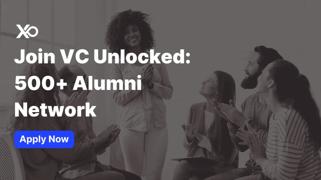 Apply to VC Unlocked alumni network banner showing a smiling woman standing while a group of peers sit around her clapping in a workshop setting.
